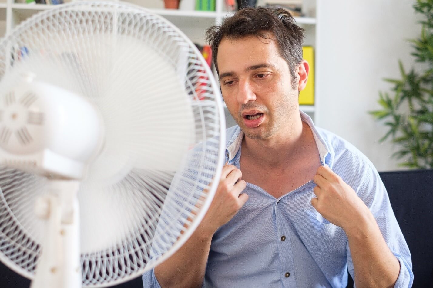Man using fan, because of heat