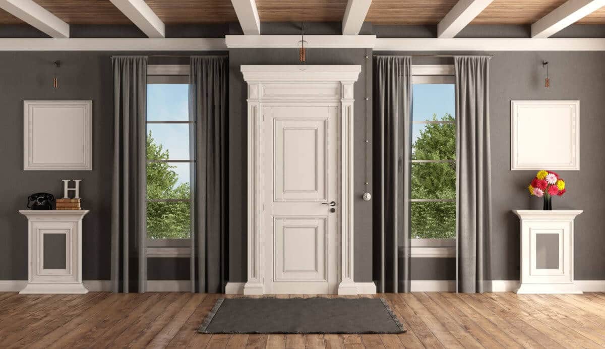 Interior shot of white front door, grey walls, and two windows